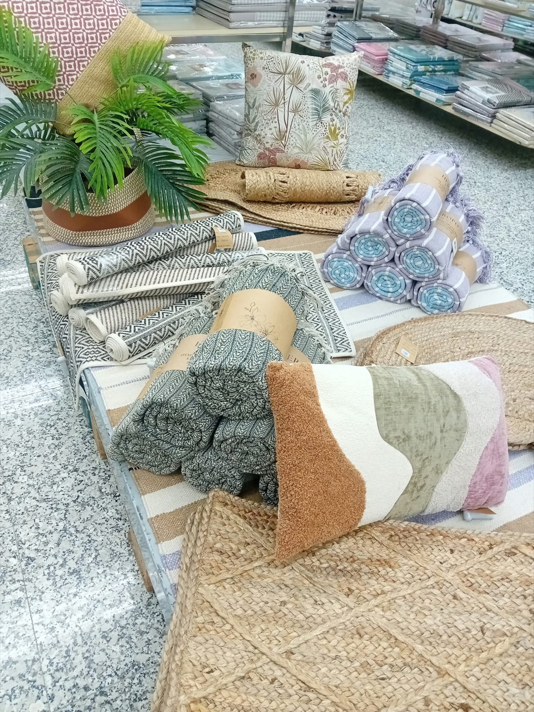 Cojines, cestas y alfombras de decoración en una tienda el 99